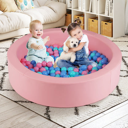 Two children and a puppy playing in the pink foam ball pit