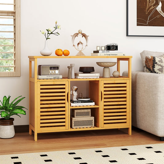 The bamboo bathroom cabinet with slatted doors and open shelves, shown in a living room setting with decorative items