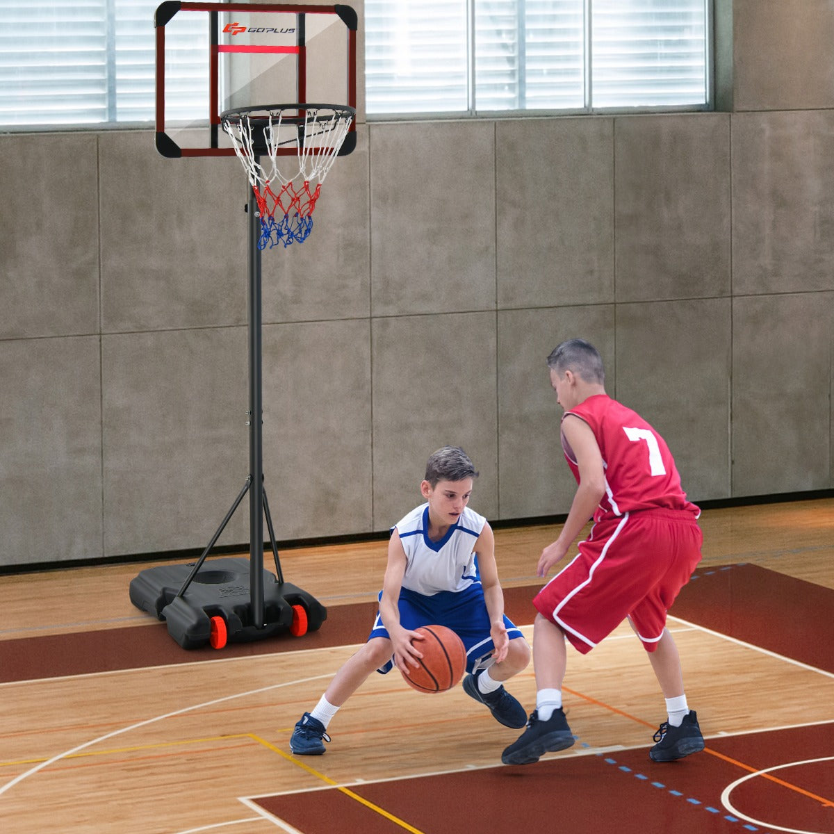 Two boys playing basketball on a wooden court with the hoop and goal set