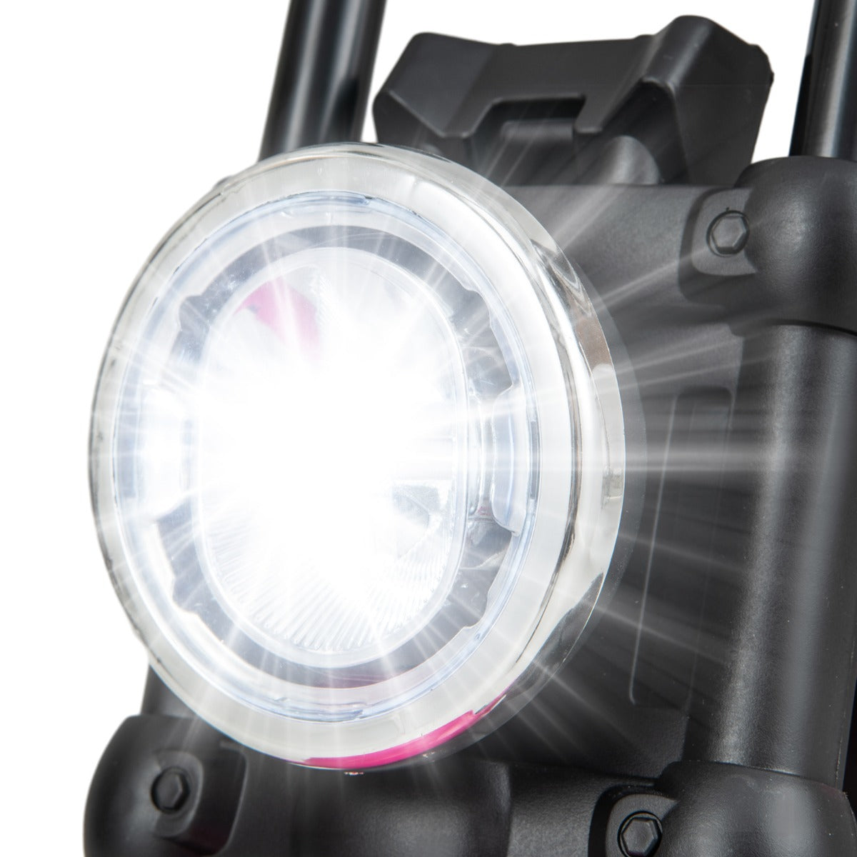 A close-up of the bright circular headlight on the front of the kids electric motorbike
