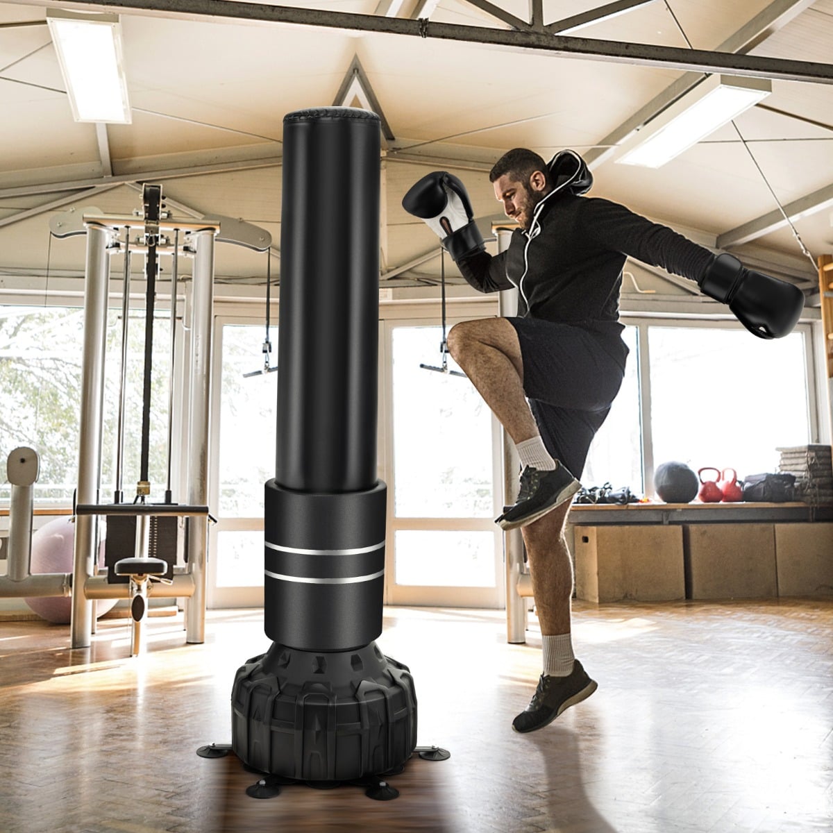 A boxing bag with boxing gloves and suction cup base in a home gym with exercise equipment