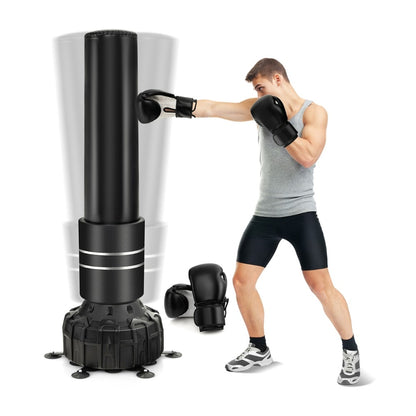 Boxing bag with boxing gloves and suction cup base, a man in a grey vest and black shorts punching the bag
