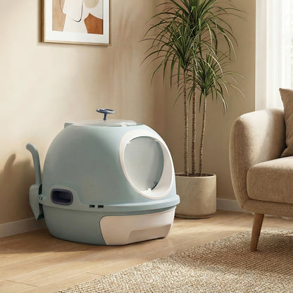 The blue helicopter style cat litter box with lid sits on a wooden floor next to a potted plant
