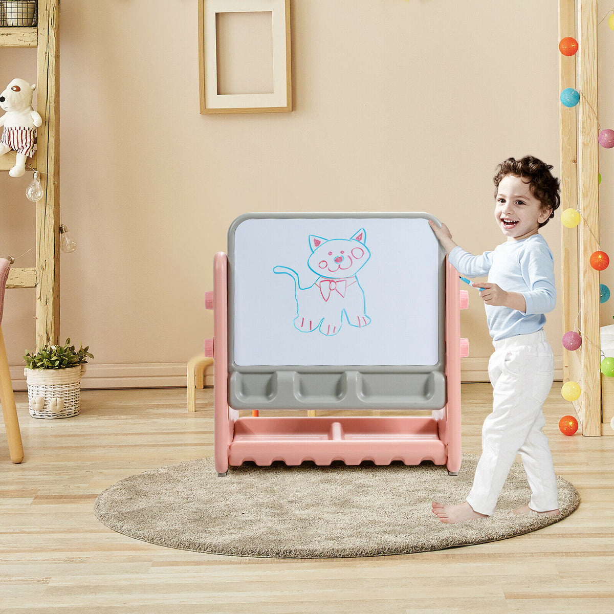 A young boy drawing on the art easel and chair set