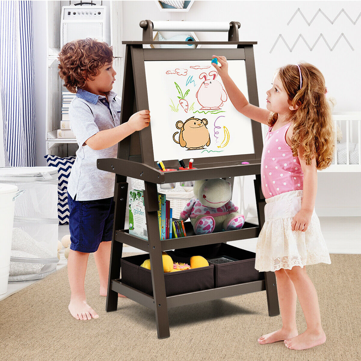 Two children drawing on the whiteboard side of the brown art easel in a room