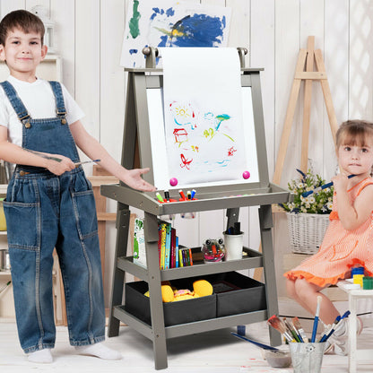 The art easel in use by two children painting on paper in a bright playroom setting