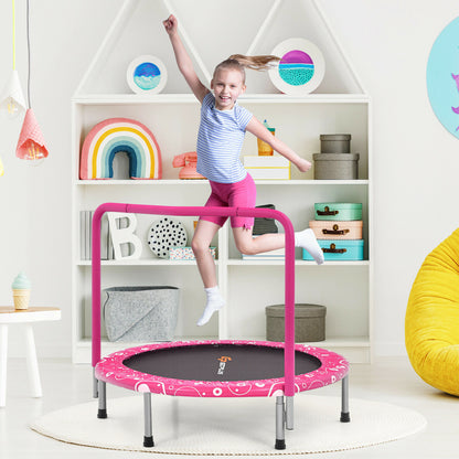 A young girl bounces on the pink folding trampoline in a bright room