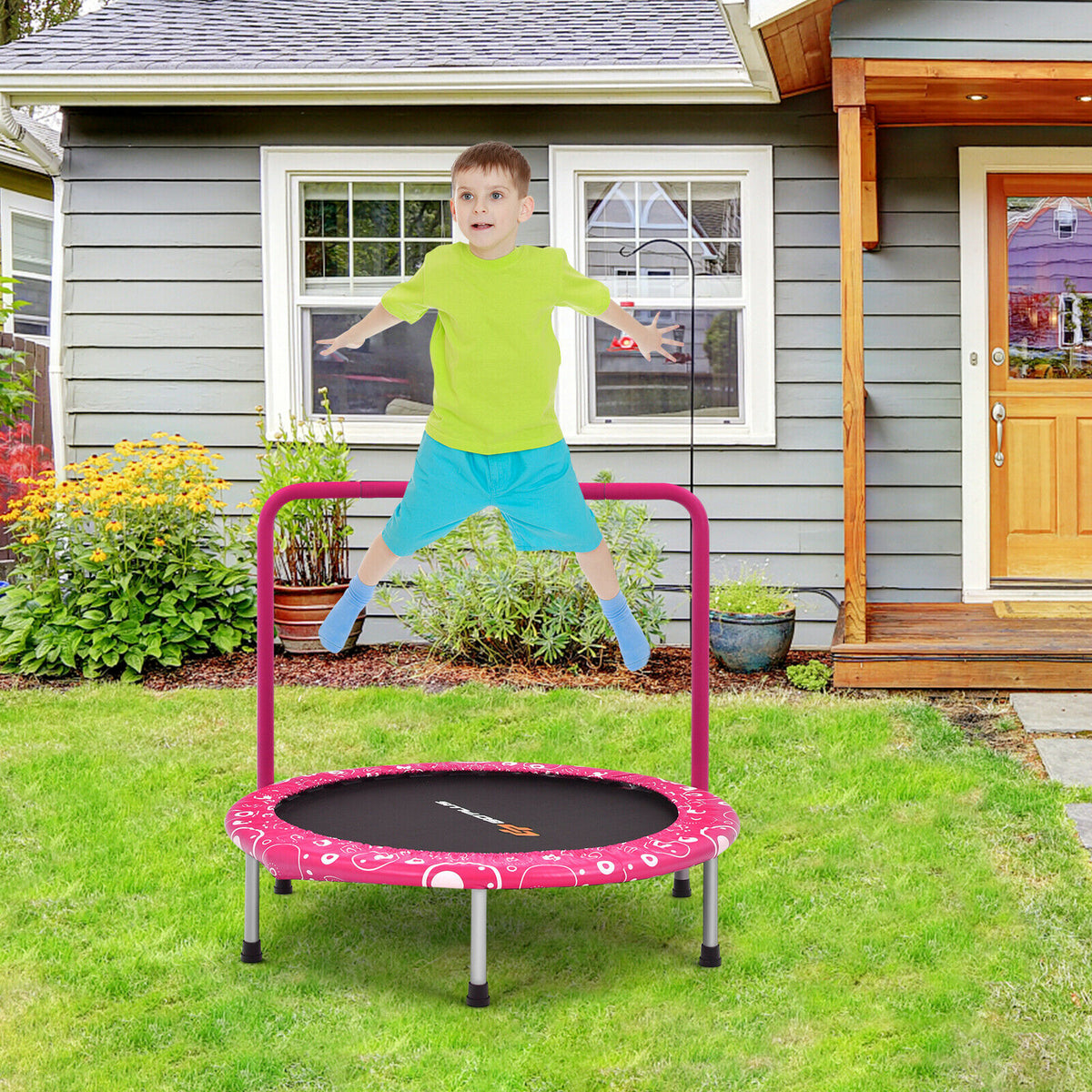 A boy jumps on the pink folding trampoline in a garden