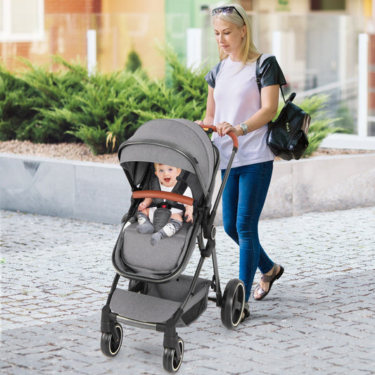 Woman pushing a baby stroller with a baby inside on a paved path
