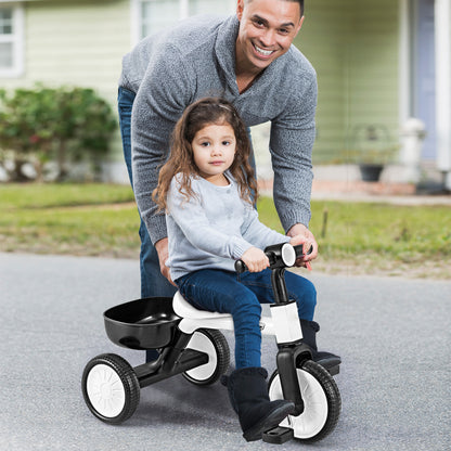 A father pushing his daughter on the white and black toddler trike outdoors