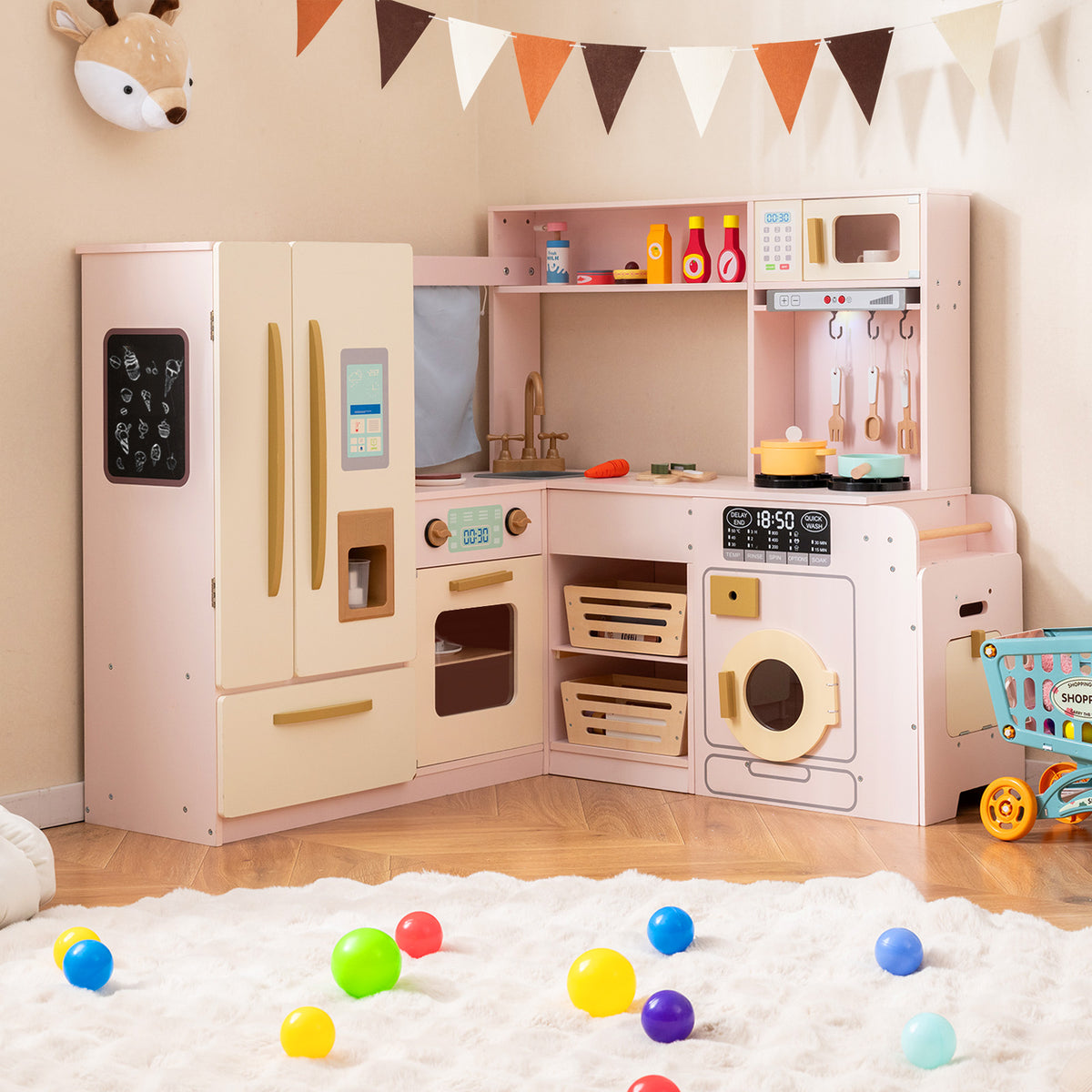 Pink corner kitchen playset with fridge, oven and washing machine set up in a child's room