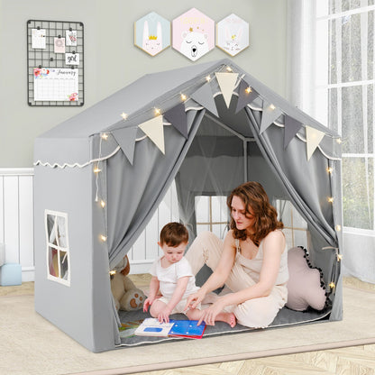 A woman and a toddler sit inside the grey play tent house, reading a book