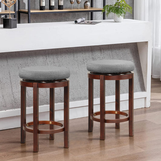 Two bar stools with grey upholstered seats and dark wood frames in a domestic setting