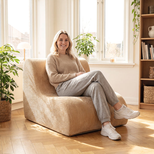 A woman relaxing on the beige corduroy floor sofa in a bright, modern living room