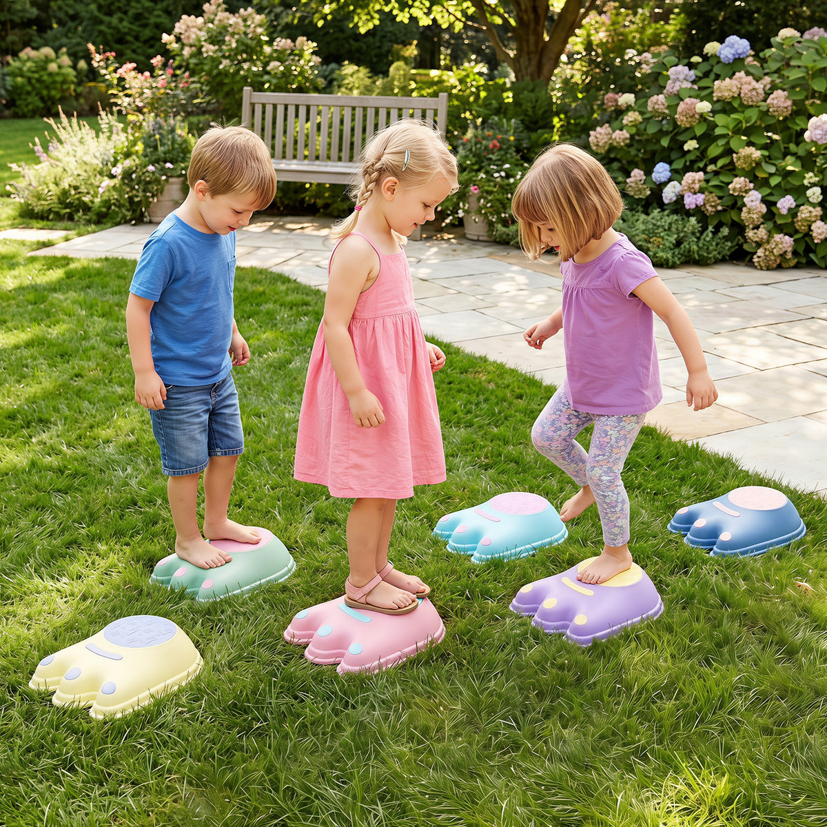 Two children playing on the monster stepping stones in a garden setting