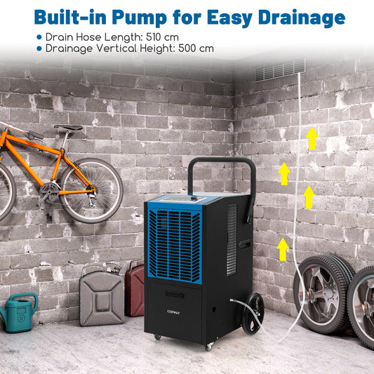 The commercial dehumidifier with a drain hose pumping water up a brick wall