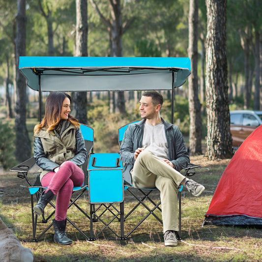 The camping furniture being used by a man and woman sitting in a forest setting