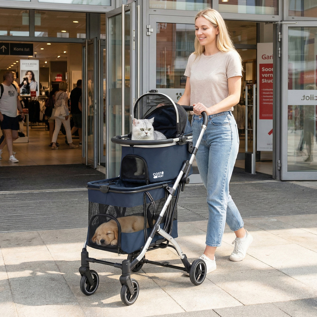 A woman pushing the navy blue pet stroller with a cat and dog inside outside a shopping centre