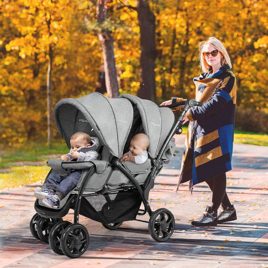 Woman pushing a grey double pushchair with two babies sitting in it on a paved path in autumn park