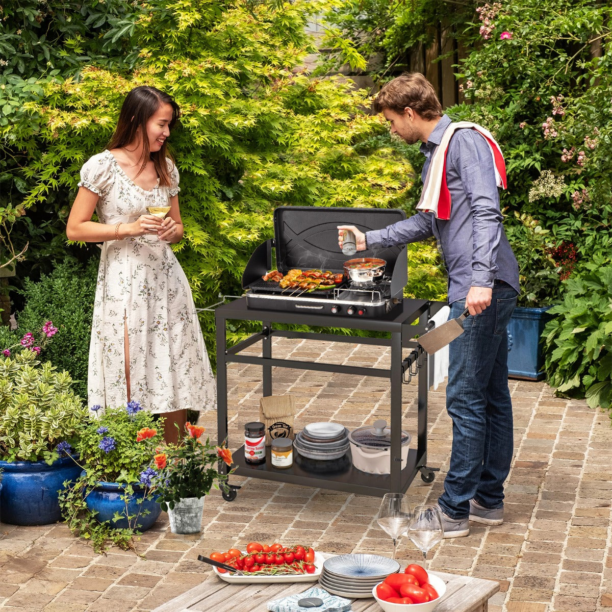 Double-Shelf Movable BBQ Cart, a couple using the outdoor trolley to prepare food in a garden setting