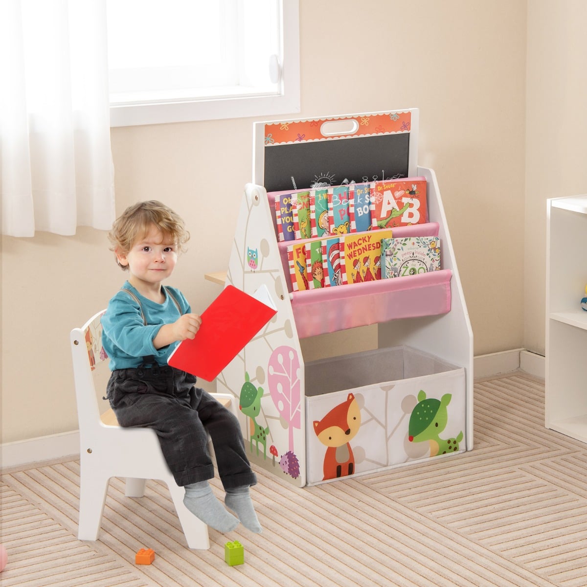 The kids art easel used as a bookshelf with a child sitting on the chair