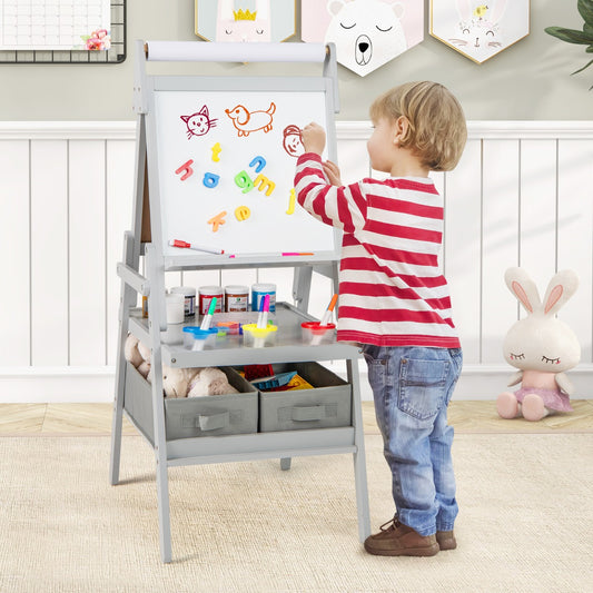 A young boy drawing on the magnetic whiteboard side of the grey art easel