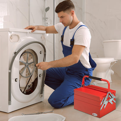 A man uses a red metal tool box while fixing a washing machine