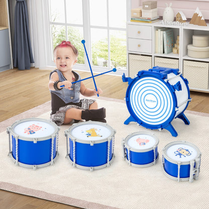 A baby sits in front of a blue drum set with smaller drums laid out