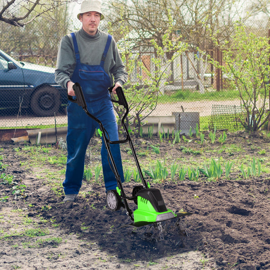 The garden tiller being operated by a person on a patch of soil in a garden setting
