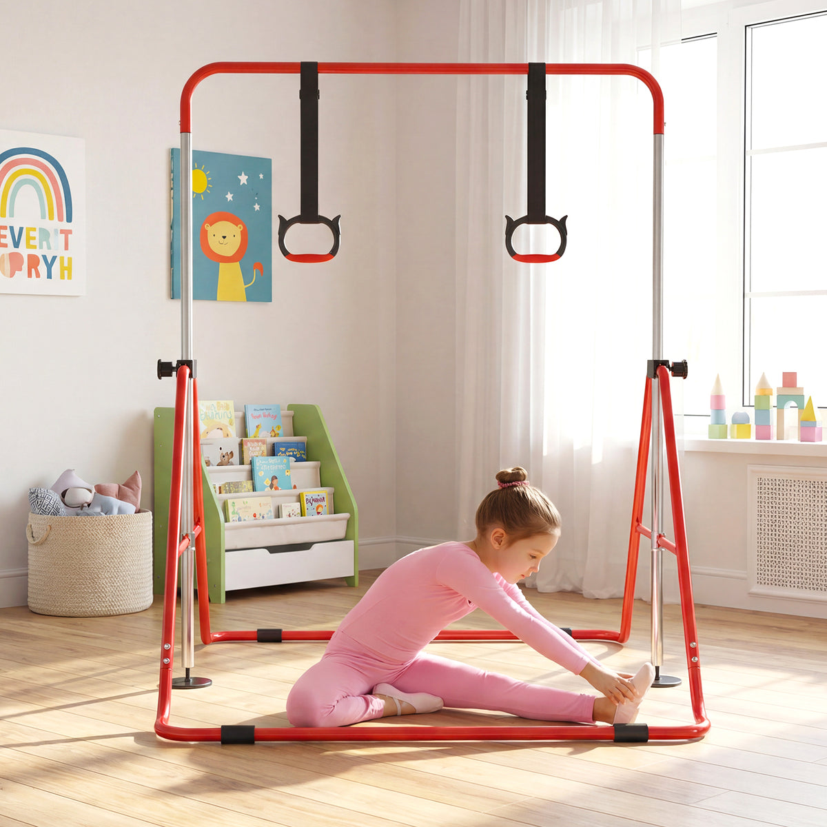 A child in pink activewear sits on the floor near the red gymnastics bar