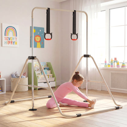A girl in pink leggings sitting on the floor next to the gymnastic bar