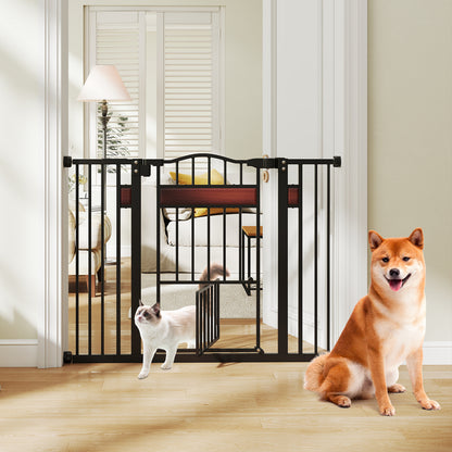 The black pet gate is open in a doorway with a cat walking through and a Shiba Inu sitting nearby