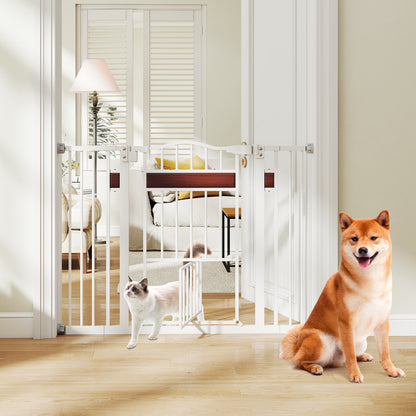 The white pet gate is fitted in a doorway with a cat passing through the small pet door