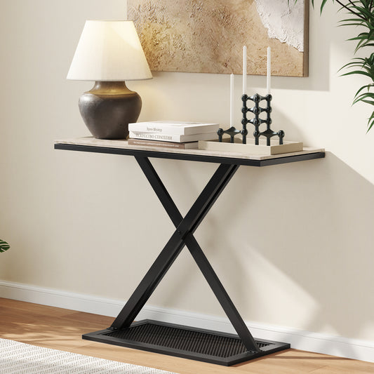 Console table with a faux marble top and black metal frame in a room setting with a lamp and books