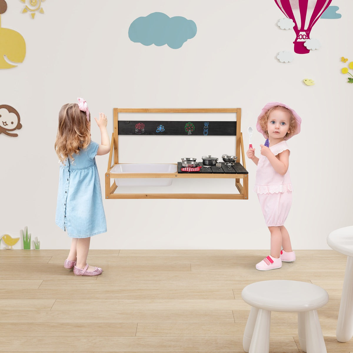 The wooden play kitchen set up in a child's room with toys