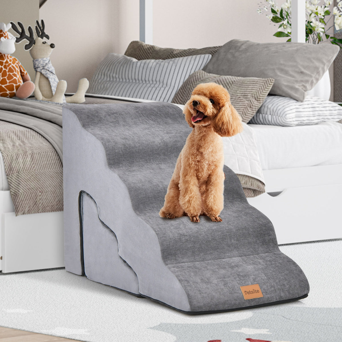 Grey foam dog stairs with a small dog on top, placed next to a bed
