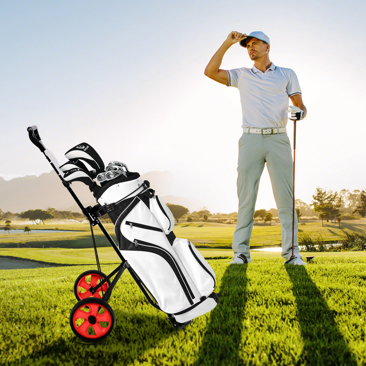 A man in a white shirt stands with the red golf cart and a golf bag on a sunny golf course