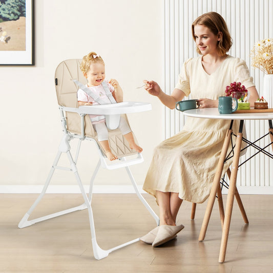 A mother feeding her baby in the beige high chair in a dining room setting