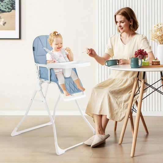 A mother feeding her baby in the navy blue high chair in a dining room setting