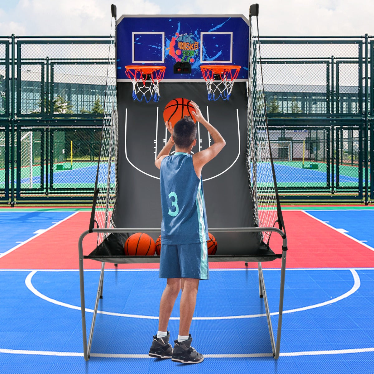 A young man playing the game room basketball arcade on an outdoor court
