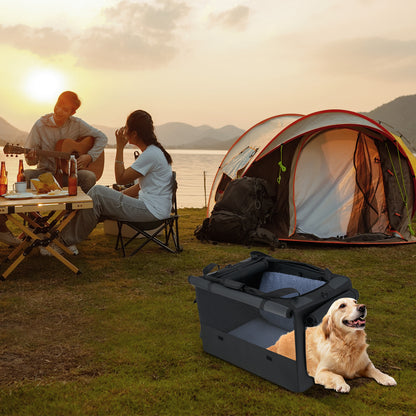 A dog resting in the dog crate at a campsite by a lake with people in the background