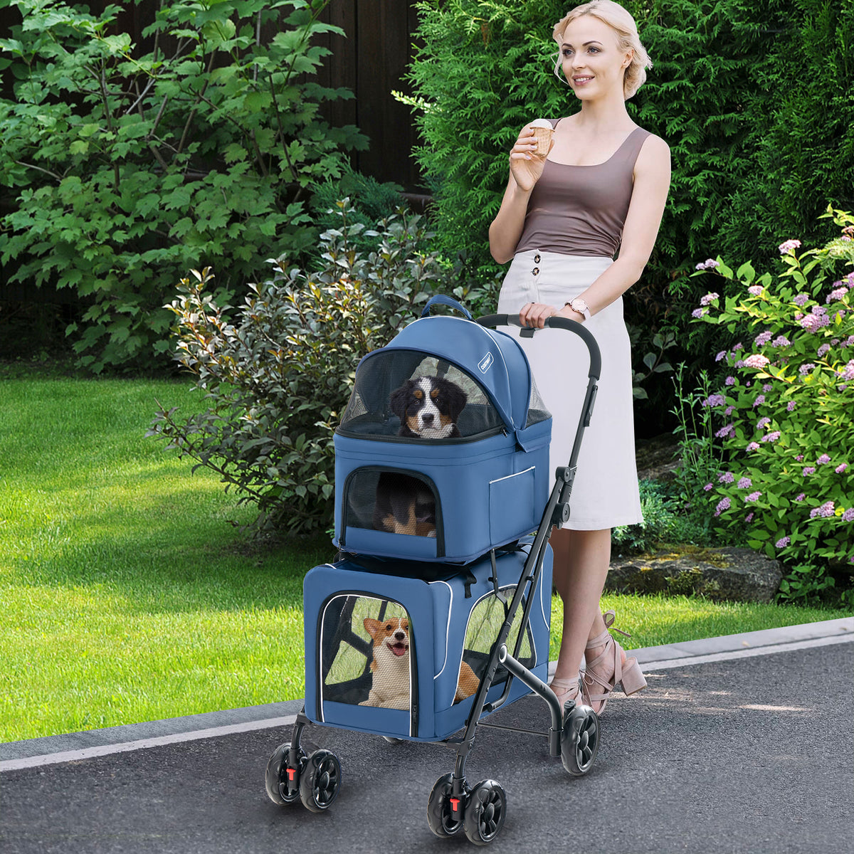 The dog stroller being pushed by a woman in a garden with three small dogs inside the carriers