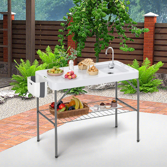 The outdoor workstation with sink set up on a patio, showing the main table surface and lower shelf