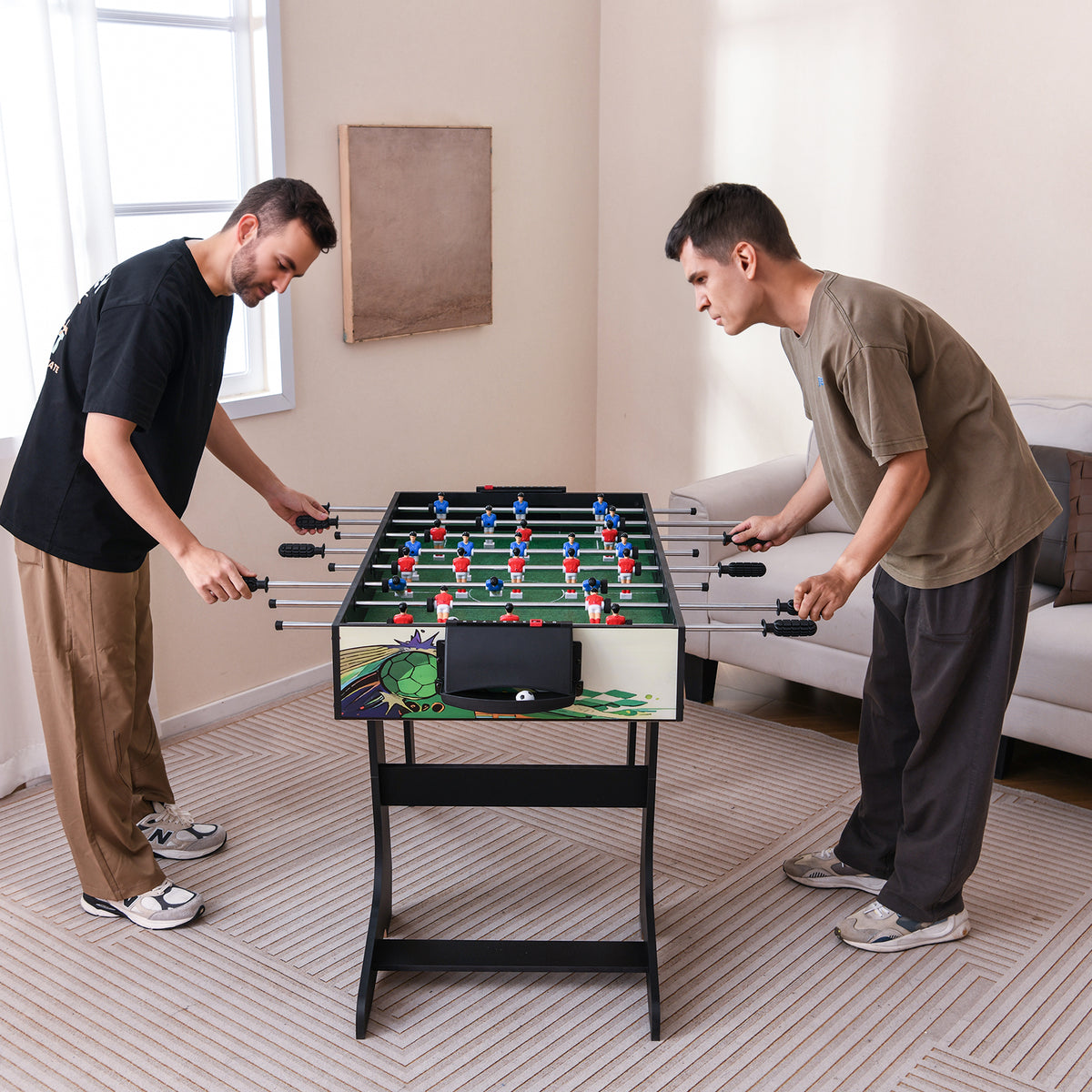 Two men playing a competitive match on the green table in a bright living room setting
