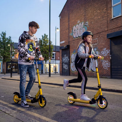 Two teenagers riding the yellow kick scooters on a street