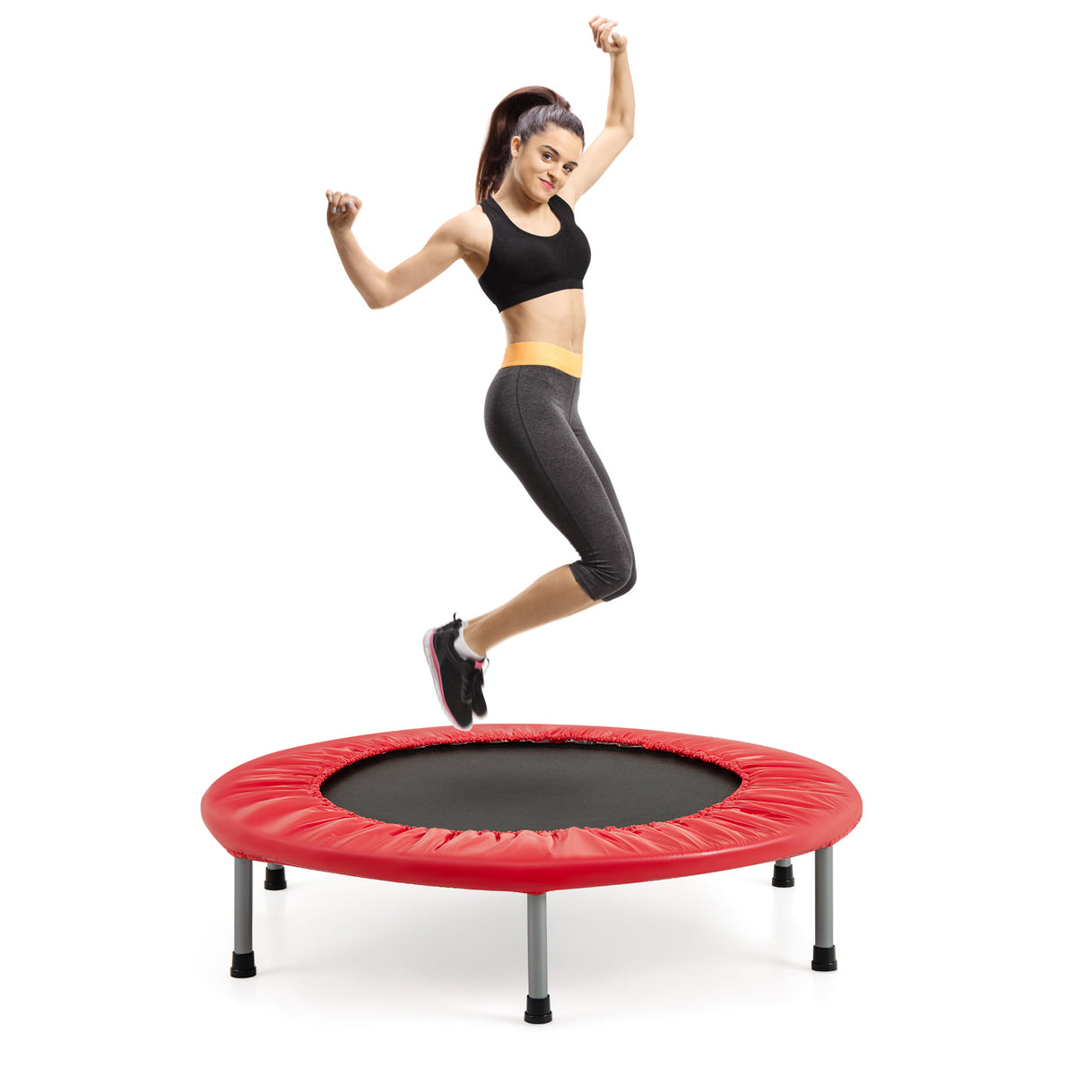 A woman jumping high on the red trampoline against a white background