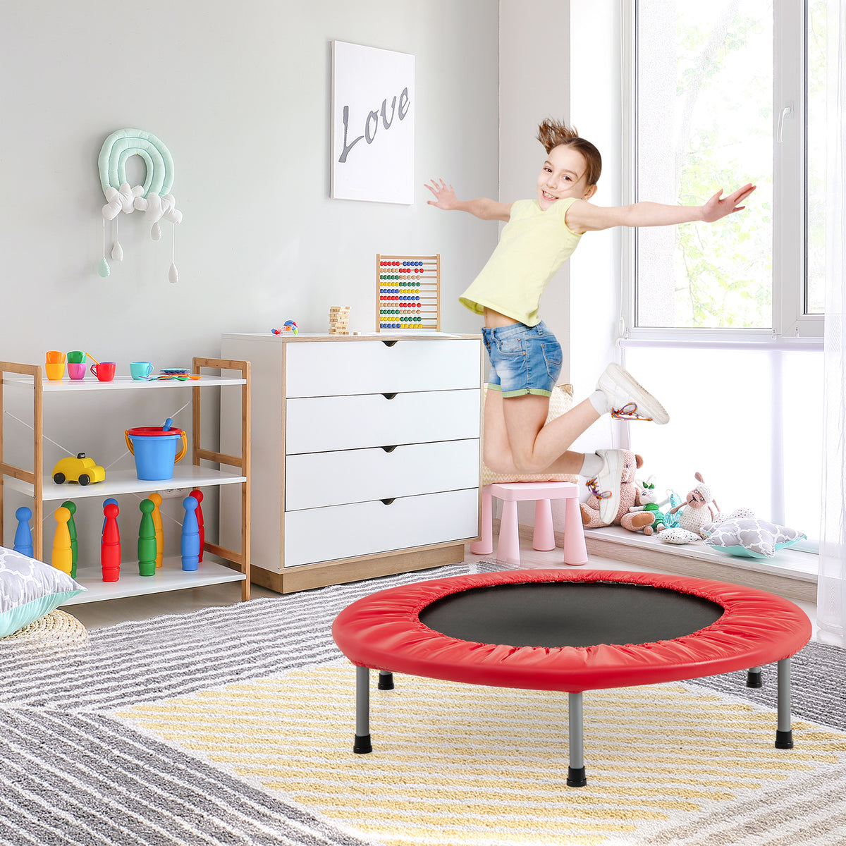 A child jumping on the red trampoline in a child's bedroom