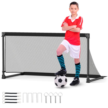 Boy in soccer kit standing with a soccer ball in front of the pop-up goal