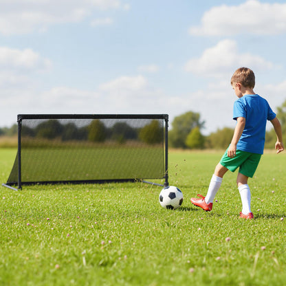 Young boy kicking a football towards the pop-up soccer goal on a field