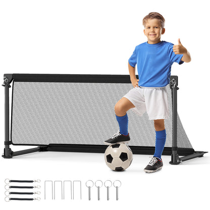Boy giving a thumbs up next to the soccer goal with a ball